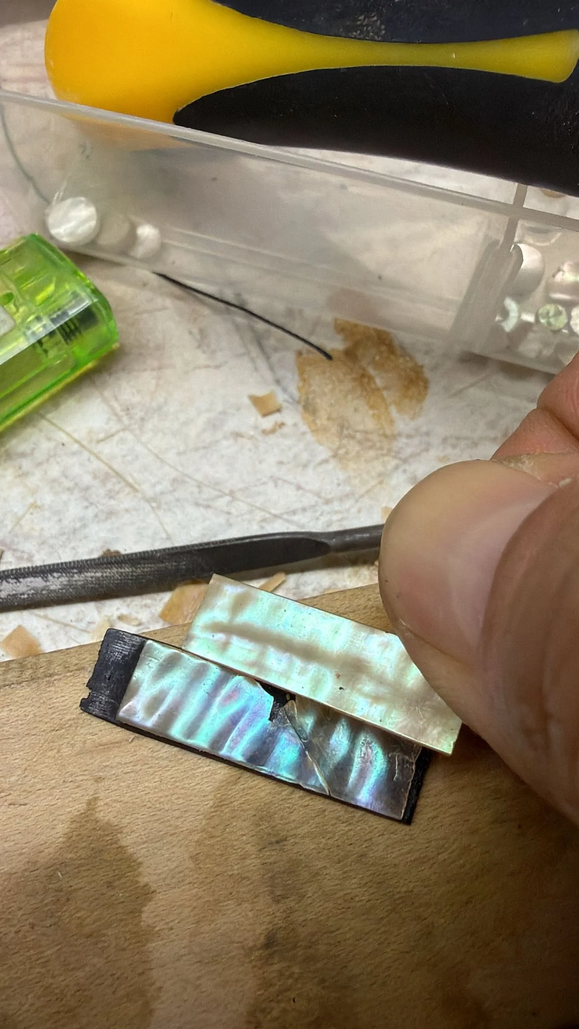 Replacement pearl bow slide fitted into a bow frog during repair work