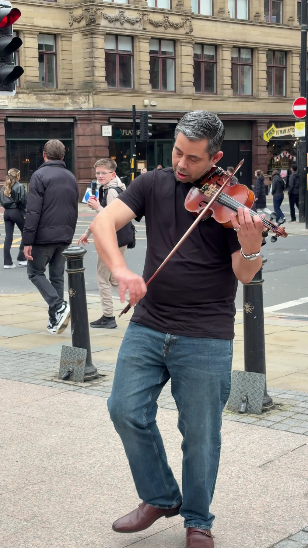 James Taylor playing acoustic violin in a city-centre street performance